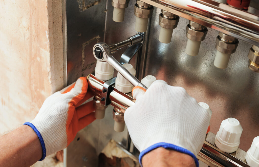 A technician in gloves repairs a water heater, ensuring proper functionality and safety during the maintenance process.