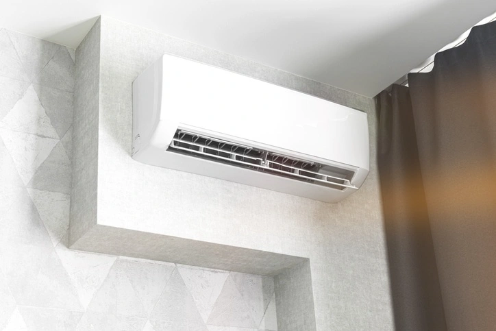 A sleek, modern air conditioner mounted on a white wall, showcasing contemporary design and efficient cooling technology.